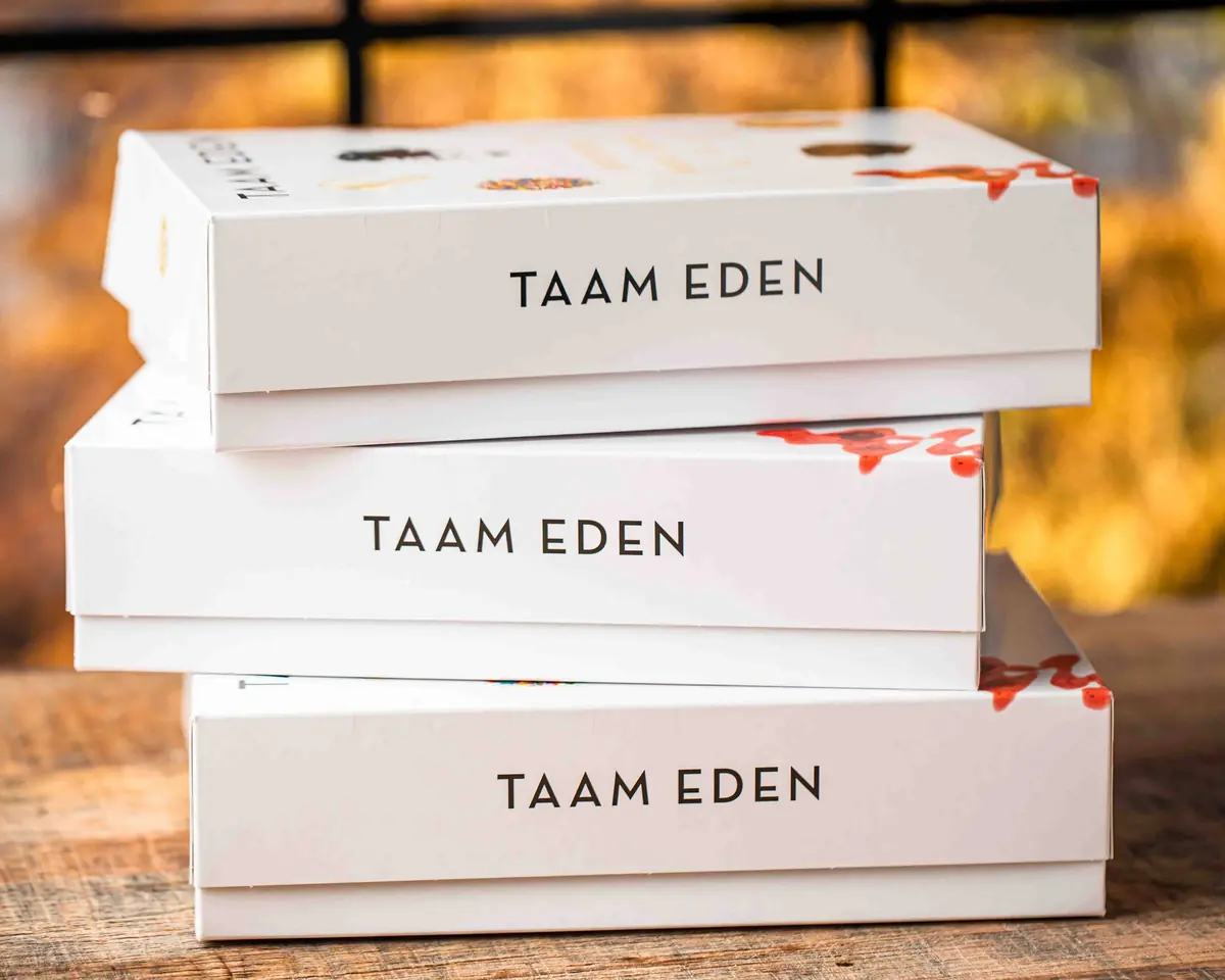 A stack of Taam Eden bakery boxes